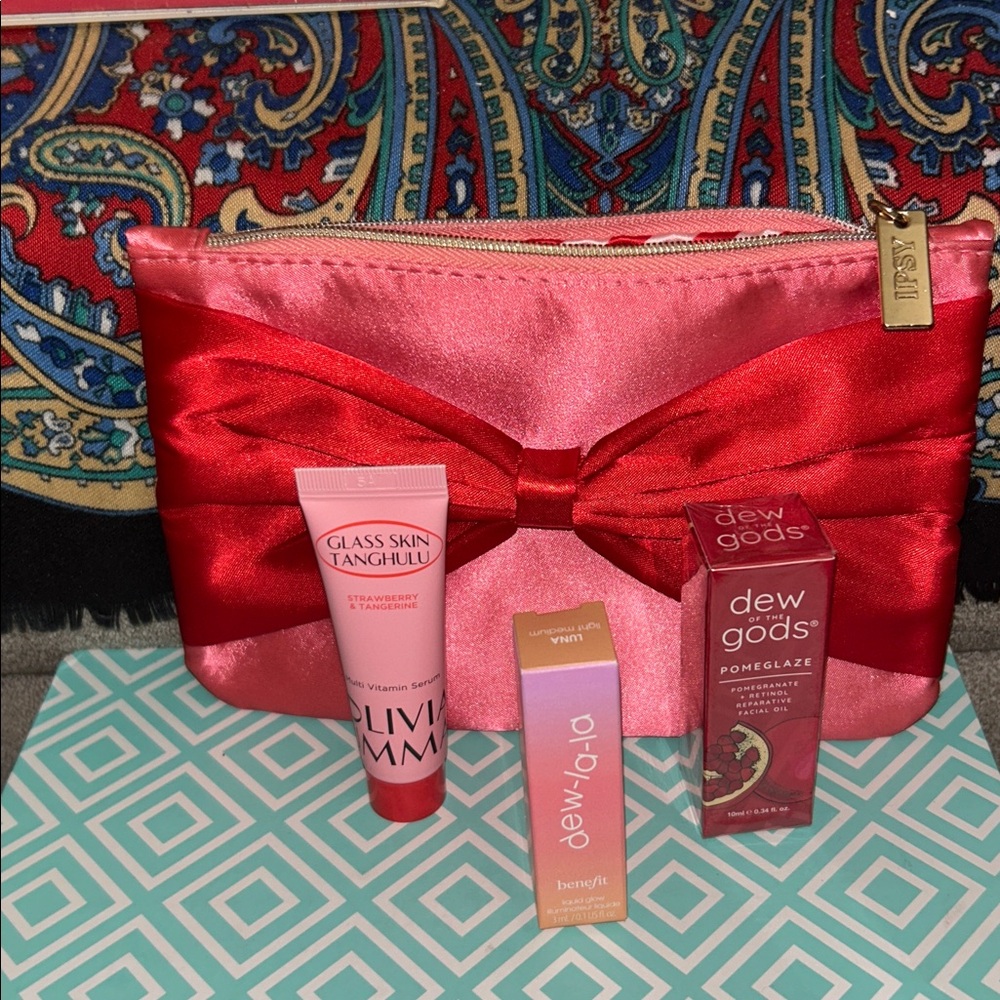 GlassSkin, Dew of the Gods, & Benefit 🌹 face/neck serum in a silk like Ipsy bag.